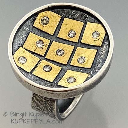 Large Round Ring with nine Gold squares. Each with a flush set Diamond